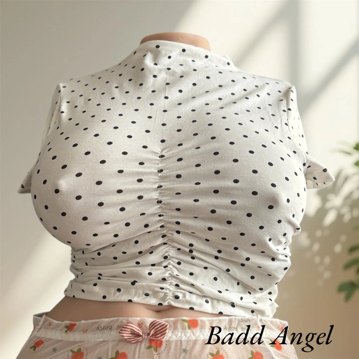 Badd Angel wearing a white top with black spots