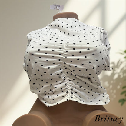 Britney wearing a white top with black spots